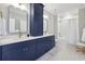 Stylish bathroom boasts double vanities, navy blue cabinets, gold hardware, and patterned tile floors at 2587 Apple Valley Rd, Brookhaven, GA 30319