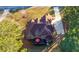 Aerial view of a two-story home with a brown roof, a deck with a red umbrella, and a spacious yard at 1415 Swiftwater Cir, Mcdonough, GA 30252