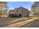 Backyard view of a brick two-story house with a deck and large lawn at 1415 Swiftwater Cir, Mcdonough, GA 30252