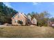 Two-story brick home featuring arched windows, a manicured lawn, and mature trees at 1415 Swiftwater Cir, Mcdonough, GA 30252