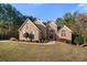 Charming two-story brick home with an arched entryway, manicured shrubs, and lush green lawn at 1415 Swiftwater Cir, Mcdonough, GA 30252