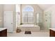 Bright bathroom featuring a soaking tub, separate shower, and large window at 1415 Swiftwater Cir, Mcdonough, GA 30252