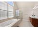 This bathroom features a soaking tub, glass shower, and neutral tile at 1415 Swiftwater Cir, Mcdonough, GA 30252