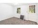 Cozy bedroom with plush gray carpet, white walls, natural light, and door access to an outdoor porch at 5520 Glore Sw Dr, Mableton, GA 30126