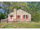Charming home featuring red shutters, a brick base, and a cozy front porch, surrounded by lush greenery and mature trees at 5520 Glore Sw Dr, Mableton, GA 30126