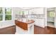 Spacious, bright kitchen with an island, new floors, white walls and appliances, and charming backsplash at 5520 Glore Sw Dr, Mableton, GA 30126