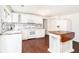 Spacious, bright kitchen with an island, new floors, white walls and appliances, and charming backsplash at 5520 Glore Sw Dr, Mableton, GA 30126