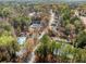 Aerial view of a neighborhood showcasing tennis courts, a swimming pool, and mature trees at 960 Whitehawk Trl, Lawrenceville, GA 30043