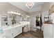 Bright bathroom featuring dual vanities, a glass enclosed shower, wood-look tile floors, and a chandelier at 960 Whitehawk Trl, Lawrenceville, GA 30043