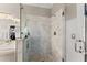Spa-like bathroom featuring a glass enclosed shower with decorative tile and a view into the main bath area at 960 Whitehawk Trl, Lawrenceville, GA 30043