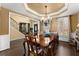 Formal dining room with tray ceiling, large windows, and hardwood floors adjacent to foyer and stairway at 960 Whitehawk Trl, Lawrenceville, GA 30043