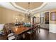 Elegant dining room with tray ceilings, dark hardwood floors, chandelier, and views into living room at 960 Whitehawk Trl, Lawrenceville, GA 30043