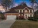 Two-story brick home with green shutters, beautiful landscaping and a two-car garage at 960 Whitehawk Trl, Lawrenceville, GA 30043