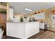 Open kitchen with white cabinets, hardwood floors, a large center island, and modern stainless steel appliances at 960 Whitehawk Trl, Lawrenceville, GA 30043