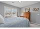 Cozy bedroom featuring a natural-wood dresser and bright window illuminating a comfortable space at 115 Dearing Woods Way, Covington, GA 30014
