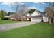 Lovely home showcasing a manicured lawn, long driveway, and an attached two-car garage at 115 Dearing Woods Way, Covington, GA 30014