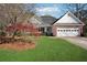 Inviting home with a neatly landscaped front yard, charming front porch, and attached garage at 115 Dearing Woods Way, Covington, GA 30014
