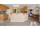 View of the kitchen with breakfast bar, wood cabinets, and open access to living and dining area at 115 Dearing Woods Way, Covington, GA 30014