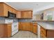 Kitchen with wood cabinets, gray countertops, and white appliances at 115 Dearing Woods Way, Covington, GA 30014