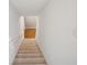 Carpeted staircase leading to the upper levels of the home, with hardwood floors visible from above at 115 Dearing Woods Way, Covington, GA 30014