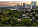 Aerial view showcases a charming neighborhood with mature trees and city skyline views at dusk at 31 Lafayette Ne Dr, Atlanta, GA 30309