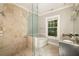 Bathroom with stone tiled shower, stone vanity and floors, and large garden tub at 31 Lafayette Ne Dr, Atlanta, GA 30309