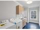 Well-lit laundry room with washer, dryer, sink, wooden cabinets, and herringbone tile floor at 2583 Apple Valley Rd, Brookhaven, GA 30319