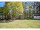 Spacious backyard with lush green grass, mature trees, play set and a storage shed at 313 Ridge Hill Cir, Canton, GA 30115