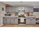 Well-lit kitchen featuring gray cabinets, stainless steel appliances, and plenty of counter space at 313 Ridge Hill Cir, Canton, GA 30115