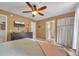 Comfortable main bedroom featuring a ceiling fan, tan walls, and a television mounted above a dark dresser at 313 Ridge Hill Cir, Canton, GA 30115