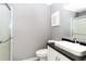 Bathroom featuring a toilet, vanity sink, mirror and shower with grey walls and white trim at 3612 Tree View Dr, Snellville, GA 30078