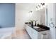 Bathroom featuring double sink, sleek black countertop, and bright lighting at 3612 Tree View Dr, Snellville, GA 30078