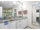 Bathroom with dual sinks, granite countertops, decorative mirrors, and a glass enclosed shower at 1143 Morningside Ne Pl, Atlanta, GA 30306