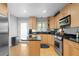 Modern kitchen featuring black countertops, light wooden cabinetry, and stainless steel appliances at 1143 Morningside Ne Pl, Atlanta, GA 30306