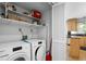 Laundry room with Miele washer and dryer, overhead storage, and view into kitchen at 1143 Morningside Ne Pl, Atlanta, GA 30306