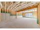 A well-lit unfinished basement with a concrete floor, exposed framing, insulation, and a window for natural light at 174 Pinewood Dr, Covington, GA 30014