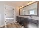 Bathroom with double sink vanity, large mirror, and wood-look floors at 174 Pinewood Dr, Covington, GA 30014