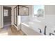 Bright bathroom featuring a soaking tub and a glass enclosed shower at 174 Pinewood Dr, Covington, GA 30014