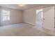 Bright bedroom features neutral walls, plush carpeting, and a window offering a view to the outdoors at 174 Pinewood Dr, Covington, GA 30014
