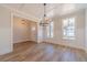 Dining room with hardwood floors, large windows, wainscoting, and a modern chandelier at 174 Pinewood Dr, Covington, GA 30014