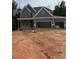 New construction home with gray siding, brick accents, and a three-car garage at 174 Pinewood Dr, Covington, GA 30014