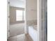 Bright bathroom featuring a large tub with tile surround and access to the bedroom at 195 Finchley Dr, Roswell, GA 30076