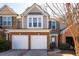 A charming two-story townhouse with a brick facade and a two-car garage offers inviting curb appeal at 195 Finchley Dr, Roswell, GA 30076