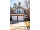 Two-story townhome with a two-car garage and brick and gray siding at 195 Finchley Dr, Roswell, GA 30076