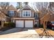 Inviting two-story townhouse showcasing a brick facade, two-car garage, and well-maintained landscaping at 195 Finchley Dr, Roswell, GA 30076