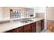 The kitchen showcases stainless appliances, cherry cabinets, a serving hatch and neutral tile flooring at 195 Finchley Dr, Roswell, GA 30076