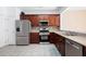 This kitchen showcases cherry cabinets, stainless appliances, stylish countertops, and neutral tile floors at 195 Finchley Dr, Roswell, GA 30076