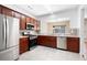 The kitchen features stainless appliances, cherry cabinets, a serving hatch and neutral tile flooring at 195 Finchley Dr, Roswell, GA 30076