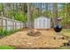 Cozy backyard with a stone fire pit, storage shed, and a charming, natural setting at 3993 Amberley Ln, Marietta, GA 30062