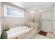 Relaxing bathroom with jetted tub, walk-in shower, and decorative tile surround at 3993 Amberley Ln, Marietta, GA 30062